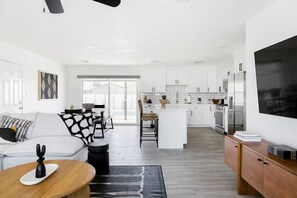A modern kitchen with white cabinets, a large island, and a built-in oven. - Scottsdale Oasis with Heated Pool, Putting Green & Fire Pit (Scottsdale)
