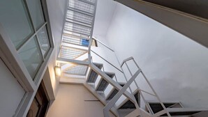 A staircase with a glass enclosure leading to an upper floor. - Campo de' Fiori | Private Rooftop Terrace (Rome)