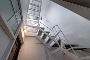 Eine Wendeltreppe mit Glasbrüstung, die zu einer oberen Etage führt.