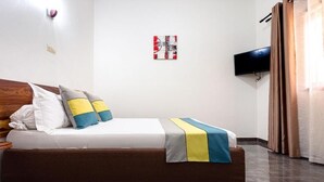A hotel room with a bed, a flat-screen TV mounted on the wall, and a curtain on the window. - Le relais de Kolda  (Kolda)