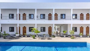 A multi-story hotel with a swimming pool, balconies, and potted plants. - Le relais de Kolda  (Kolda)