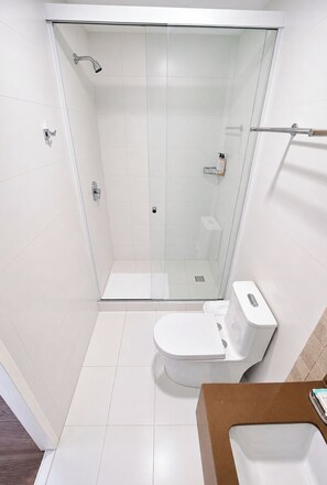 A modern bathroom with a glass-enclosed shower, a white toilet, and a sink. - Patrimonial Hotel Boutique (Cochabamba)