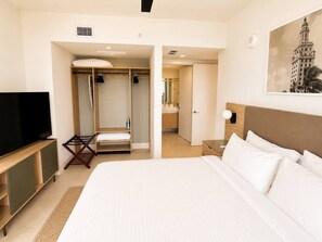 A hotel room with a large bed, a TV, a wardrobe, and a bathroom. - Beautiful 2 Bed 2 Bath with balcony in Downtown (Miami)