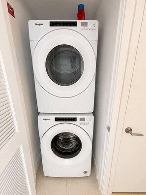 A compact laundry room with two stacked Whirlpool washing machines. - Beautiful 2 Bed 2 Bath with balcony in Downtown (Miami)