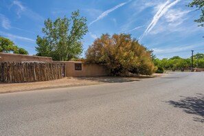 A paved road with a fence on one side and trees on the other. - Elegant Upscale Adobe Casita in Los Ranchos de Albuquerque District (Los Ranchos de Albuquerque)