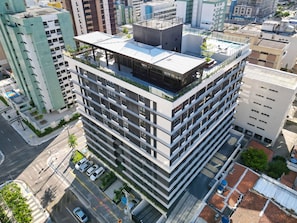 A multi-story building with a rooftop terrace and a parking area. - Move By Hosppedar (João Pessoa)