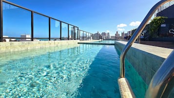 Una piscina cristalina con un horizonte urbano de fondo.