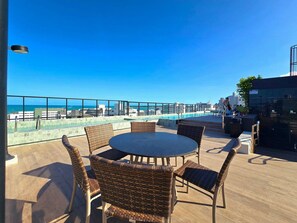 Una terrazza sul tetto con piscina, posti a sedere all'aperto e vista sulla città.