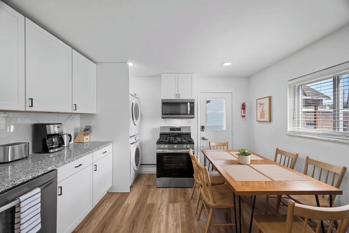 A compact kitchen with white cabinets, a built-in oven, a microwave, and a coffee maker.