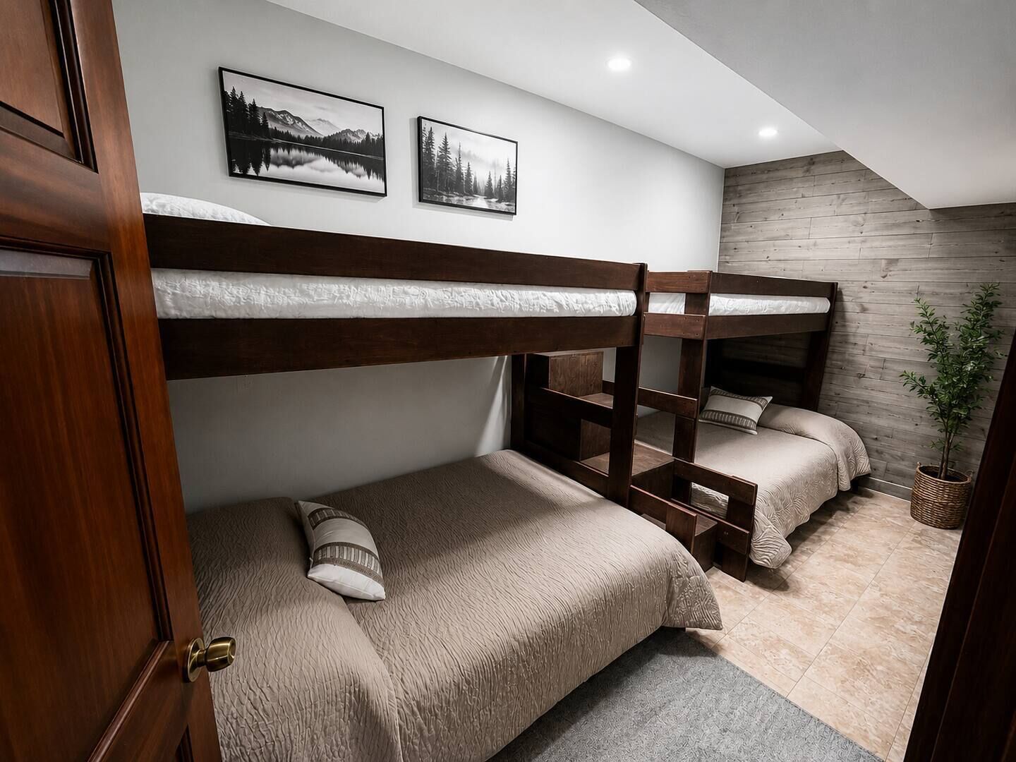 A bunk bed room with a wooden headboard, a small bedside table, and a wall-mounted shelf.