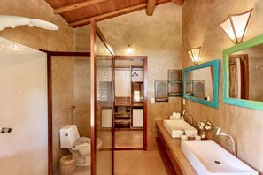 A bathroom with a wooden ceiling, a large mirror, and a sink with a towel rack. - Paraíso Casa Branca (Arraial d'Ajuda)