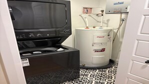 A compact laundry room with a washer, dryer, and water heater. - Two bedroom cozy apartment in central location, 15 minute from historic downtown (St. John's)