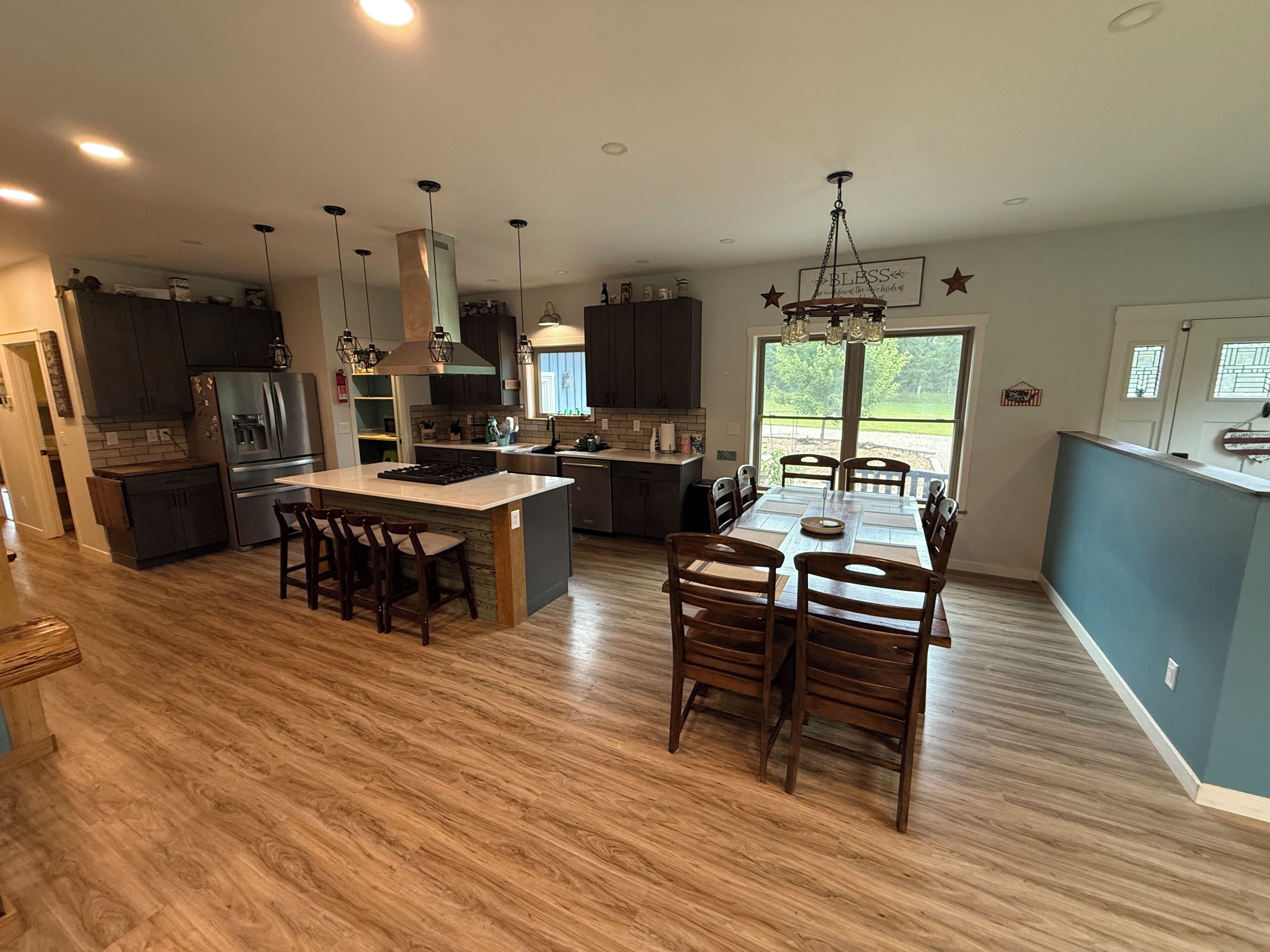 Una cocina moderna con una isla central, sillas de madera y una mesa de comedor.