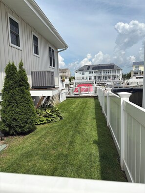 A residential property with a well-maintained lawn, a white fence, and a large house with multiple windows and a balcony. - Sea View Harbor Bayfront with boat slip and jet ski docks.This 3-2 includes Pool (Longport)