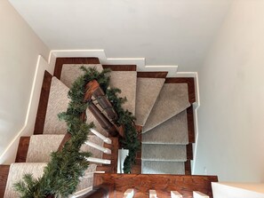 Eine Treppe mit hölzernem Geländer und Teppichstufen.