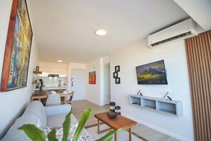 A modern living room with a sofa, a coffee table, and a TV mounted on the wall. - Refugio en el Mar Despierta frente al Caribe (Porlamar)