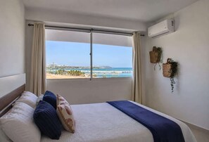 A hotel room with a bed, a view of the sea, and an air conditioning unit. - Refugio en el Mar Despierta frente al Caribe (Porlamar)