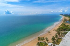 A coastal view with a beach, palm trees, and a clear sky. - Refugio en el Mar Despierta frente al Caribe (Porlamar)