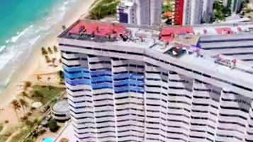 Een hoog hotel met zwembad en uitzicht op het strand.