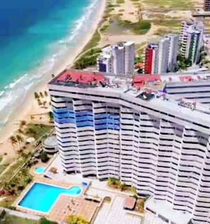 A high-rise hotel with a pool and beach view. - Refugio en el Mar Despierta frente al Caribe (Porlamar)