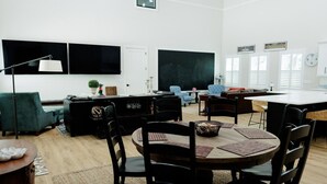 Uma sala de estar moderna com área de jantar, um quadro negro e uma janela grande.