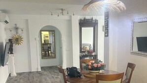 A dining area with a round wooden table, four chairs, and a vase of flowers. - Well-located apartment (Platja de l'Arenal)