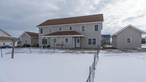 A two-story residential building with a flat roof and multiple windows, surrounded by a snowy landscape. - A 2-story, 3-bedrooms, 2.5 bathrooms with 3 hospitals that are 1 - 25 miles away (Lowville)