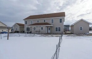 A two-story residential building with a flat roof and multiple windows, surrounded by a snowy landscape. - A 2-story, 3-bedrooms, 2.5 bathrooms with 3 hospitals that are 1 - 25 miles away (Lowville)