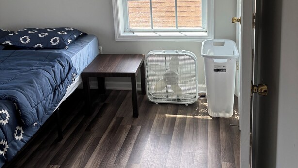 A bedroom with a bed, a window with a view, a bench, and a trash bin. - A 2-story, 3-bedrooms, 2.5 bathrooms with 3 hospitals that are 1 - 25 miles away (Lowville)