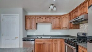 A kitchen with wooden cabinets, a granite countertop, a stove, and a dishwasher. - A 2-story, 3-bedrooms, 2.5 bathrooms with 3 hospitals that are 1 - 25 miles away (Lowville)