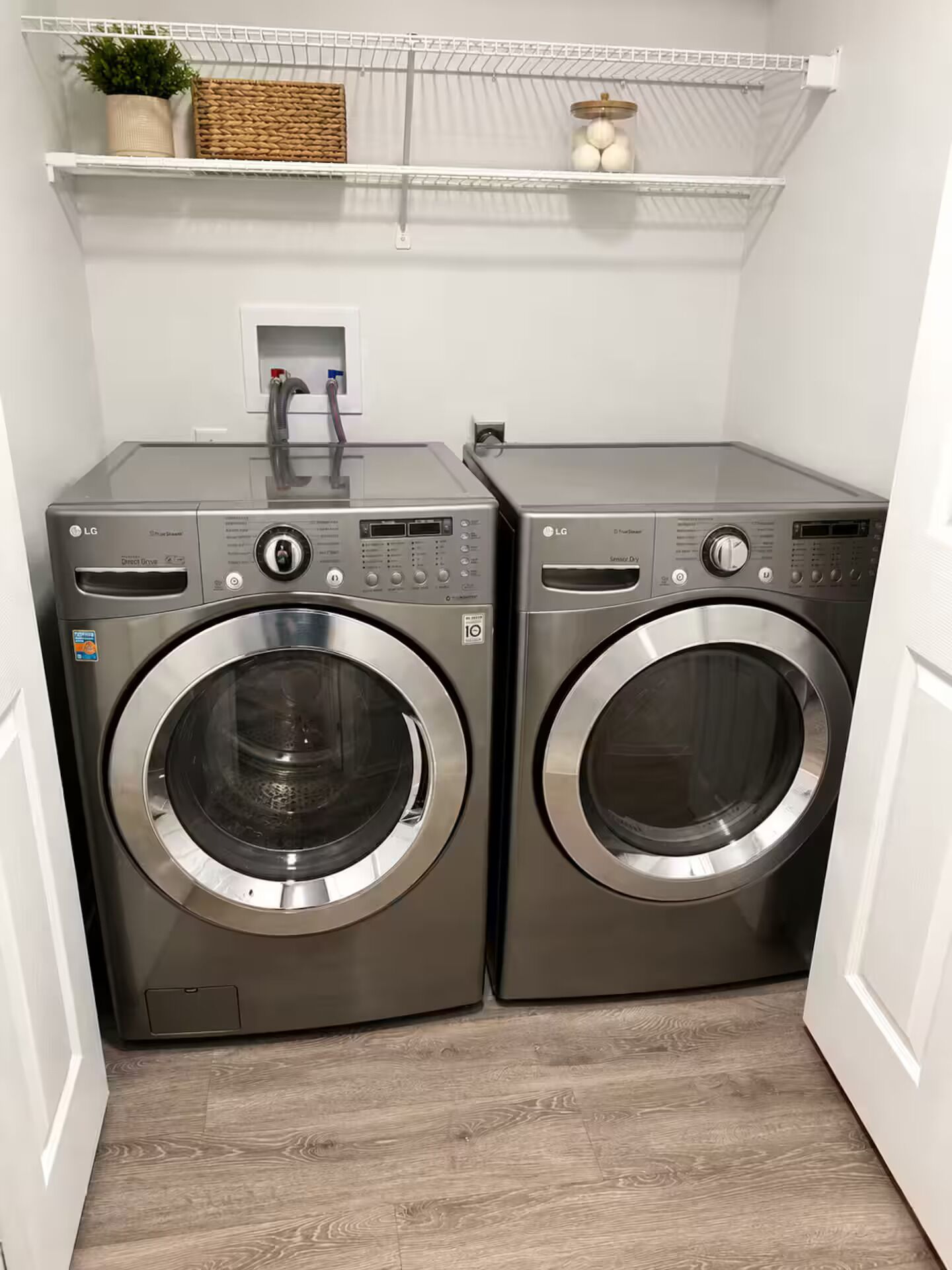A laundry area with two front-loading washing machines and a shelf above.