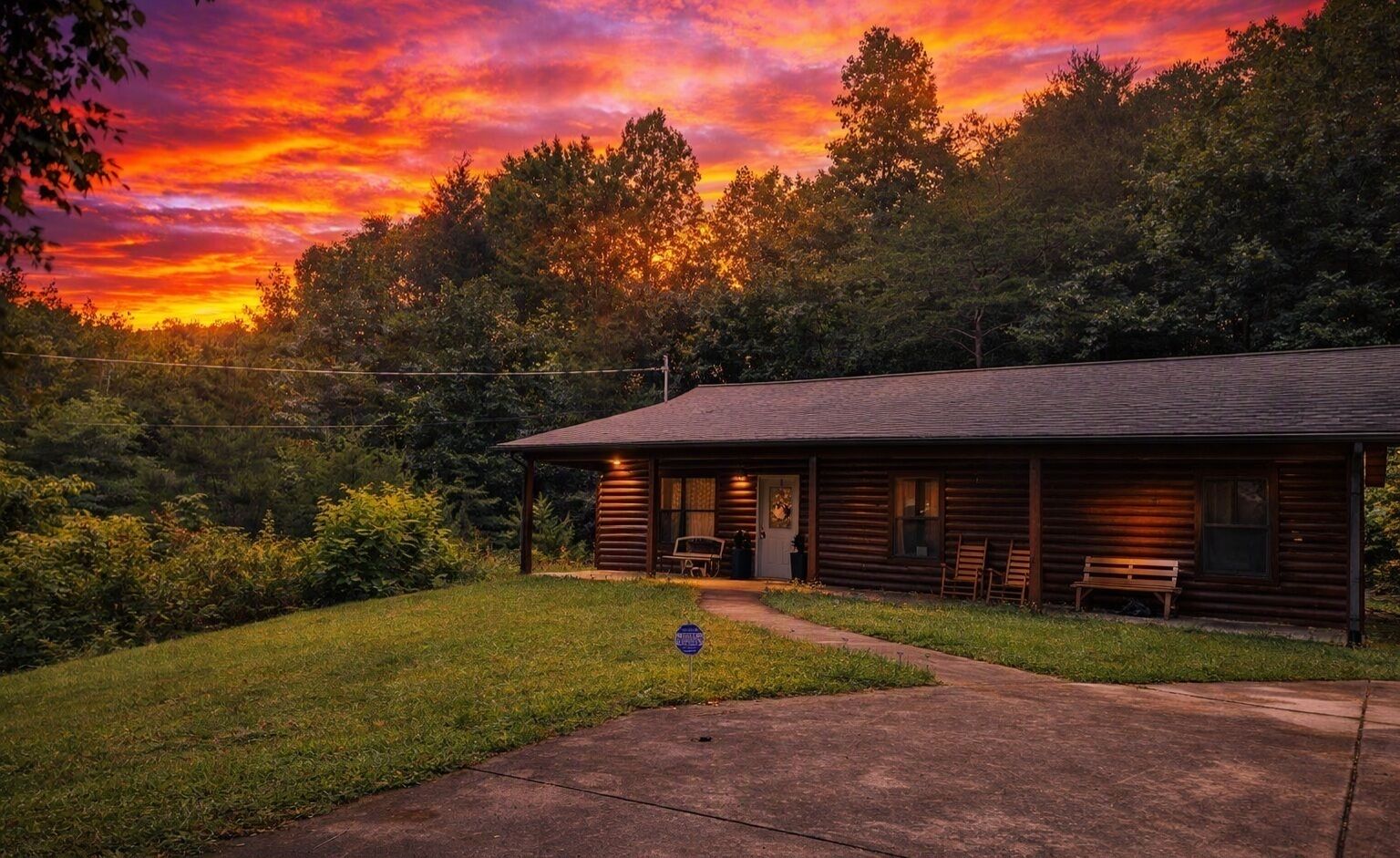 A log cabin with a porch, a bench, and a small table.