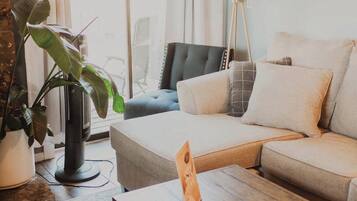 Un salon avec un canapé, une table basse, une lampe et une plante en pot.