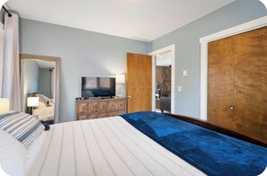 A hotel room with a bed, a television, a dresser, and a wardrobe.