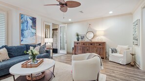 A living room with a sofa, armchair, coffee table, and a cabinet. - Santa Rosa Beach luxury 30A townhome near beach, pool, restaurants & relaxation! (Santa Rosa Beach)