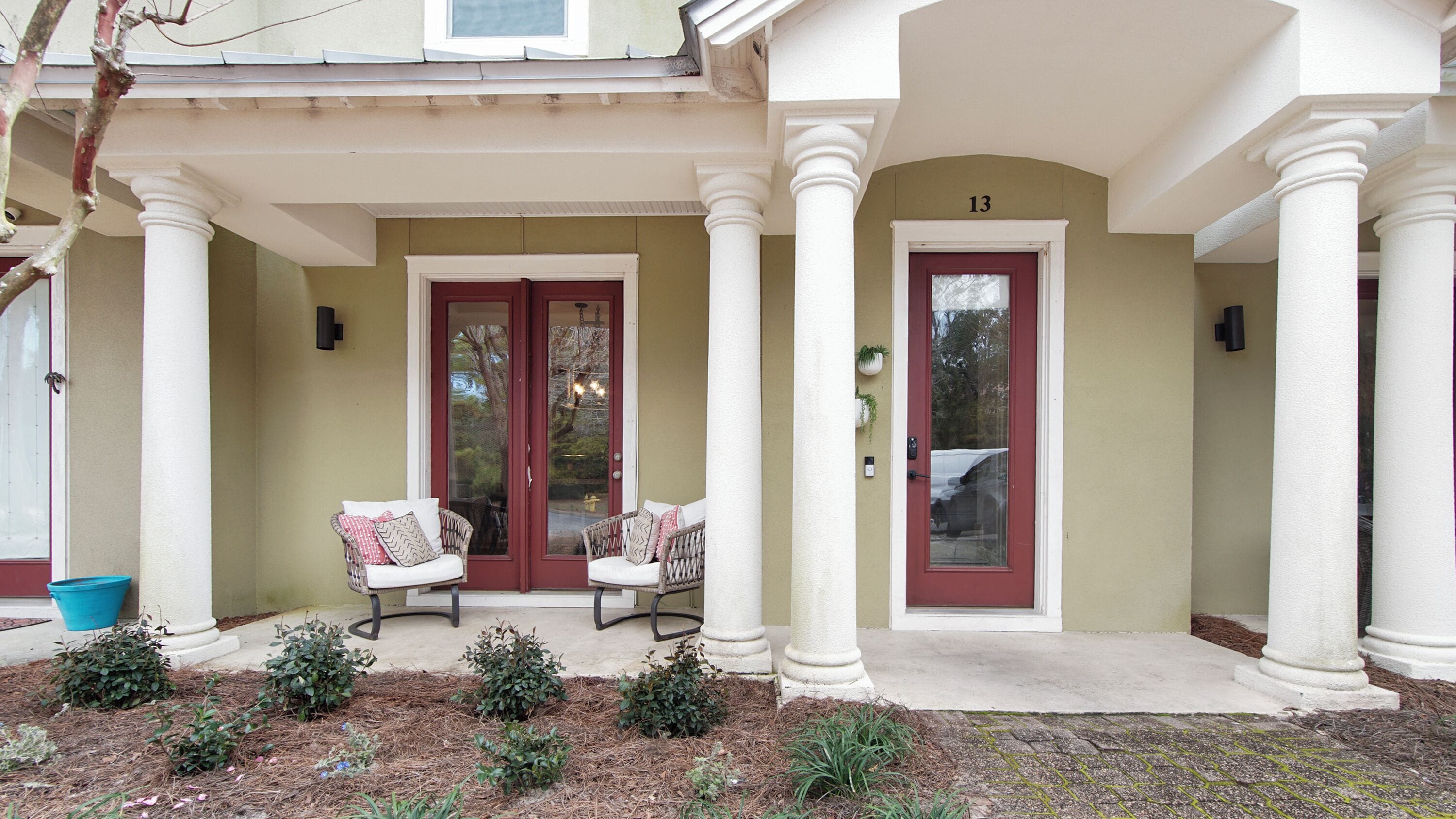 A building with a porch, two doors, and a number '13' above one door.
