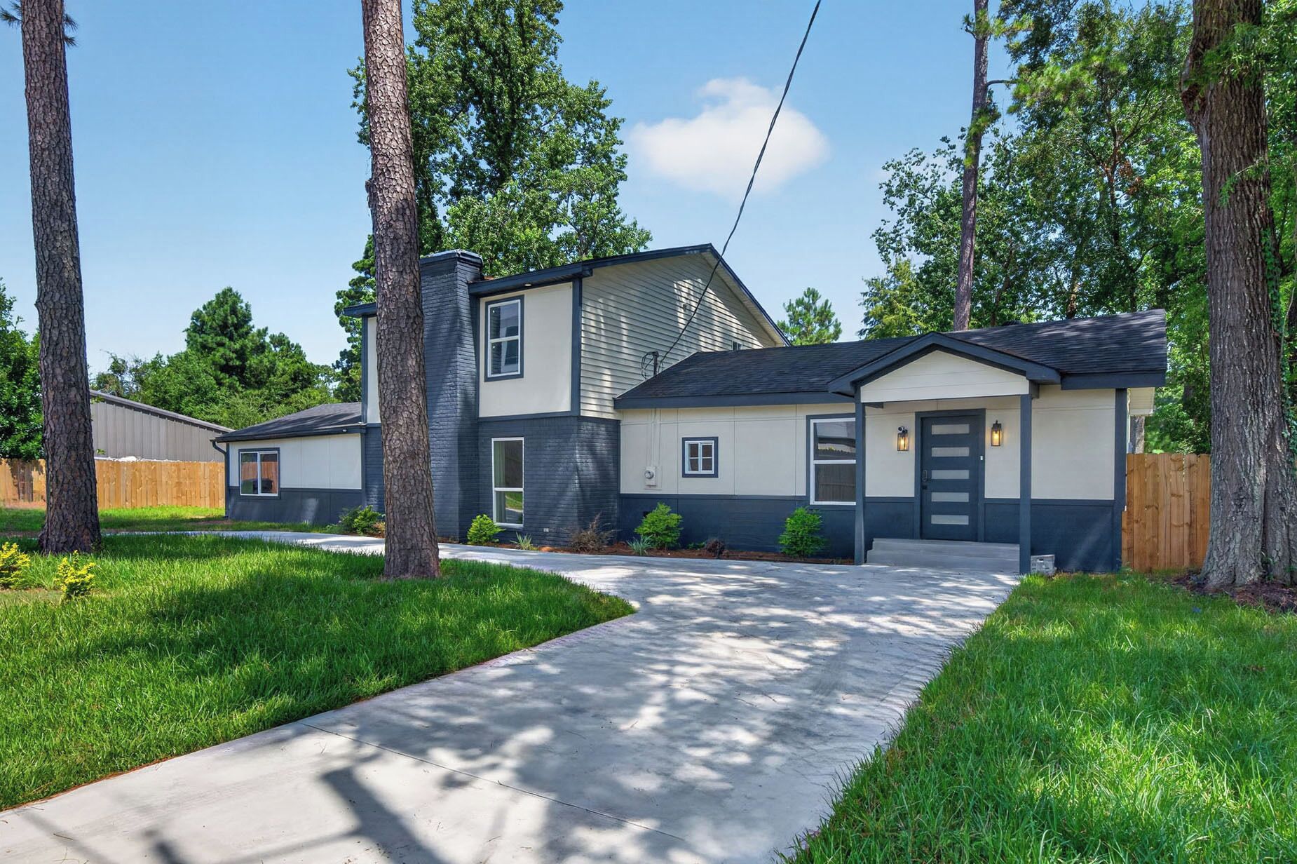 A modern two-story house with a covered front porch, a garage, and a well-maintained lawn.
