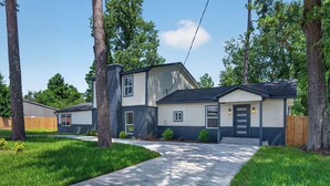 A modern two-story house with a covered front porch, a garage, and a well-maintained lawn.