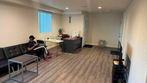 Un salon comprenant un canapé, une table basse, un meuble pour la télévision et un bureau.