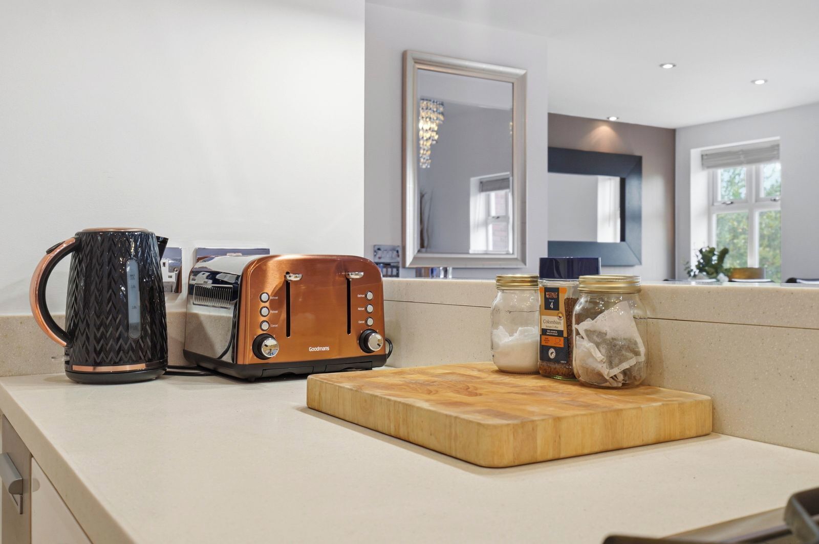 A kitchen with a toaster, a coffee maker, and jars on the counter.