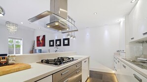Een moderne keuken met een gasfornuis, roestvrijstalen apparatuur en een strak design.