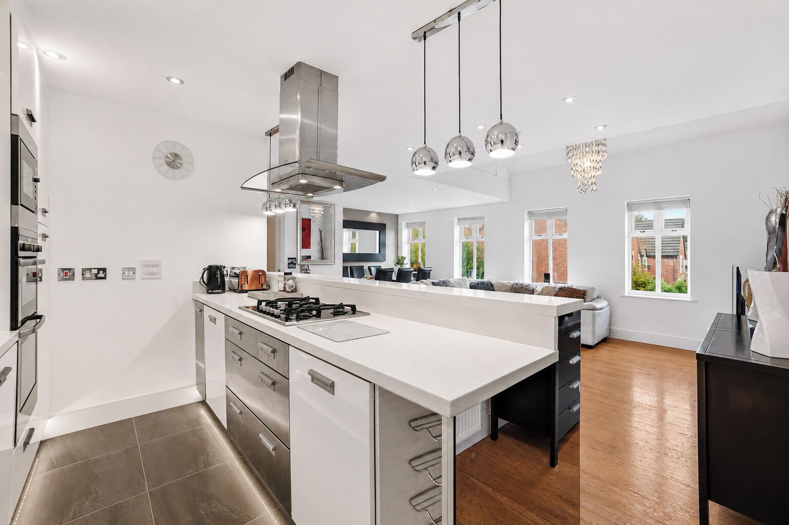 A modern kitchen with a central island, stainless steel appliances, and pendant lighting.