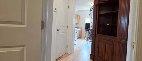 Un couloir avec une armoire en bois et une porte blanche.