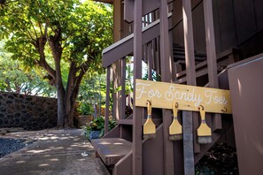 A wooden sign with the text 'For Sandy Toads' hanging on a staircase railing. - Beautiful Beach Bungalow (Kihei)