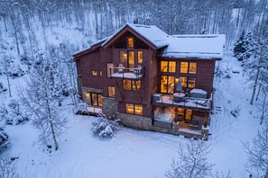 A multi-story wooden cabin with a balcony, surrounded by a snowy forest. - Scenic Mountain Village Stay | Hot Tub + Gym (Mountain Village)