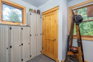 A room with a wooden door, a window with a view of trees, and a shelf with decorative items. - Scenic Mountain Village Stay - Hot Tub , Gym (Mountain Village)