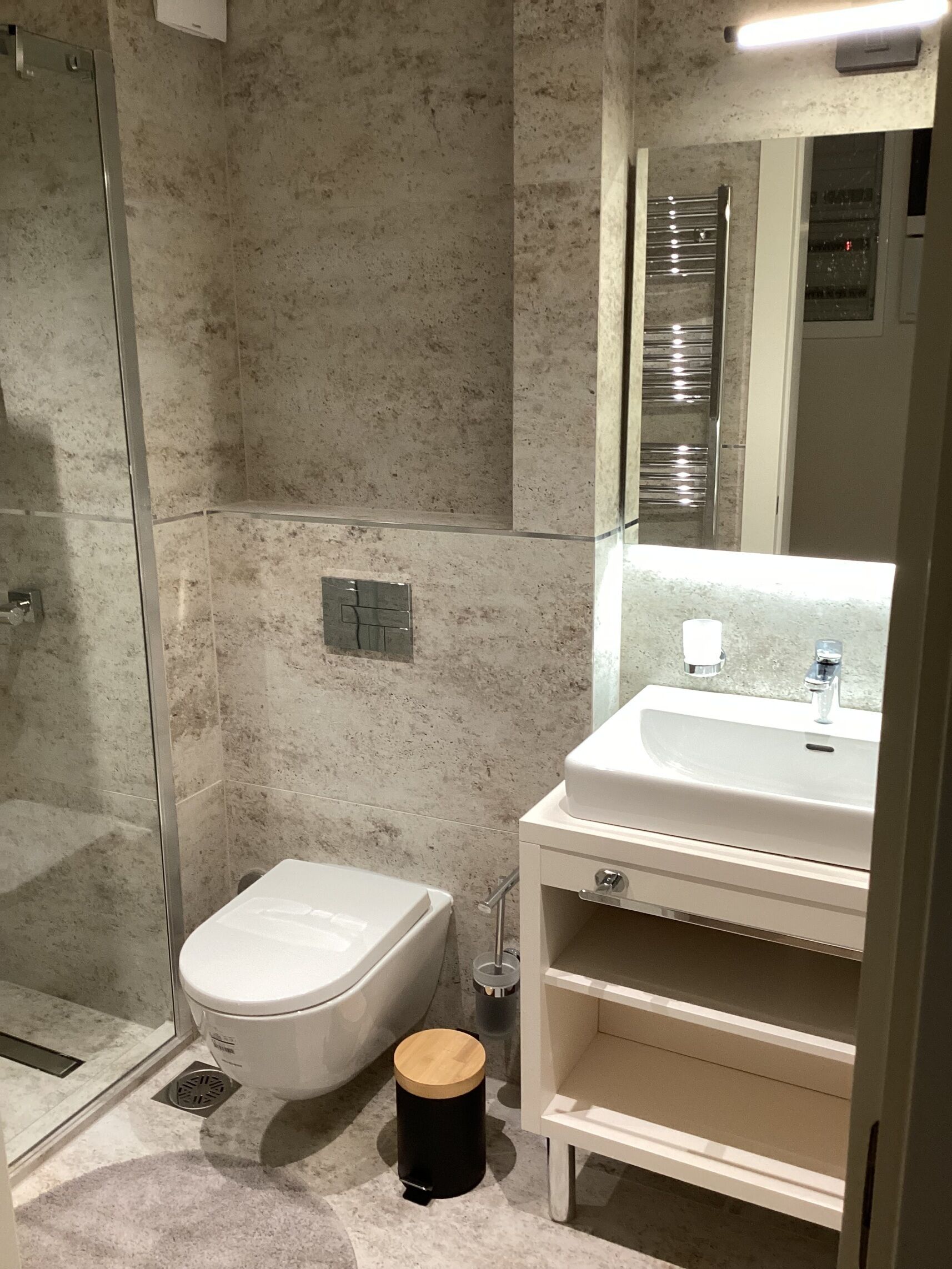 Een badkamer met toilet, wastafel en douche.