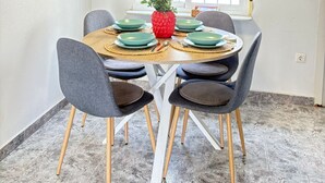 A dining area with a round table, four chairs, a hanging pendant light, and a window with a view. - Townhouse in a quiet neighborhood (El Chaparral)