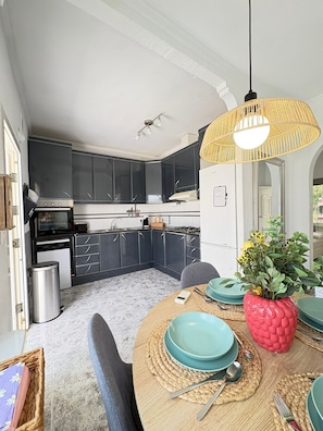 A modern kitchen with dark cabinets, a built-in oven, and a white refrigerator. - Townhouse in a quiet neighborhood (El Chaparral)