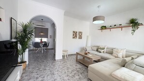 A modern living room with a sofa, coffee table, and dining area. - Townhouse in a quiet neighborhood (El Chaparral)